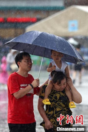 市民冒雨前行?！°蟛?攝