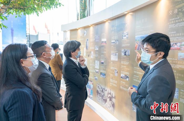 “同舟共濟(jì) 志同道合”港穗雙城圖片展覽在香港交易廣場(chǎng)開幕，圖為香港嘉賓觀看展覽?！∠愀鄣胤街局行墓﹫D