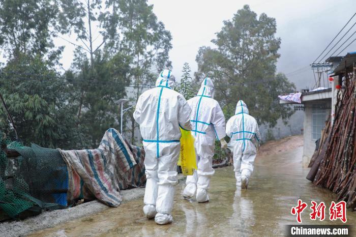 圖為在德?？h隆桑鎮(zhèn)果甫村，身著厚重防護(hù)服的歐秋潔和同伴步履蹣跚地行走。