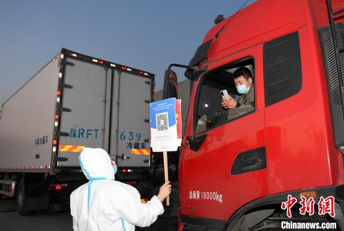 工作人員舉牌讓貨車司機(jī)掃碼?！⊥鮿?攝