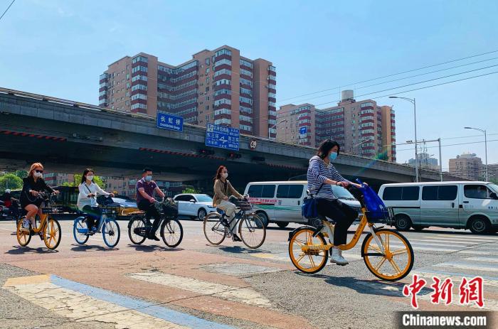 5日，北京東三環(huán)附近正騎單車出行的市民。