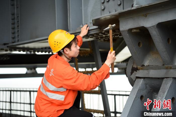 6月24日，南鐵九江橋工段的橋梁工正在九景衢鐵路鄱陽湖大橋上對高強度螺栓進行檢查更換?！?黃旸 攝