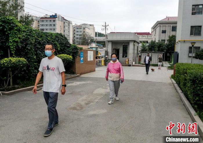 烏魯木齊市沙依巴克區(qū)國道社區(qū)，市民保持距離在小區(qū)內(nèi)散步?！＄娦?攝