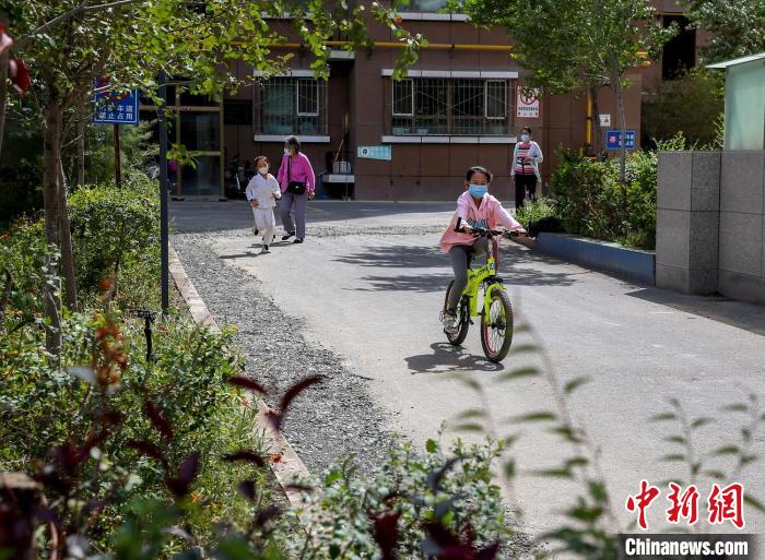 烏魯木齊市水磨溝區(qū)七道灣東街南社區(qū)，居民下樓在小區(qū)內(nèi)活動(dòng)。　鐘欣 攝