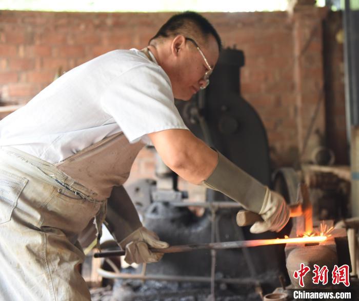 王二兵在對燒制的劍進行鍛打。　高占峰 攝