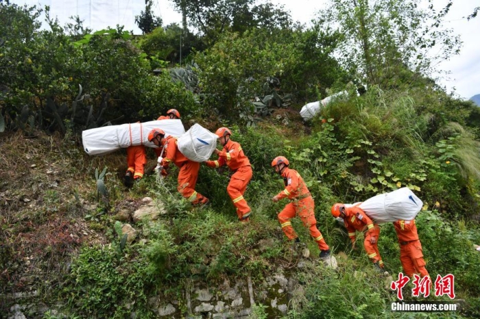 資料圖：消防員徒步運送帳篷物資。 張浪 攝