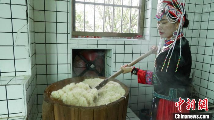 圖為藍(lán)春花鏟出煮熟的糯米進(jìn)行釀酒。　記者華山 攝