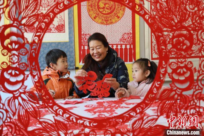 非遺傳承人田桂芹在帶領(lǐng)孩子們進(jìn)行迎新年剪紙創(chuàng)作?！±詈?攝