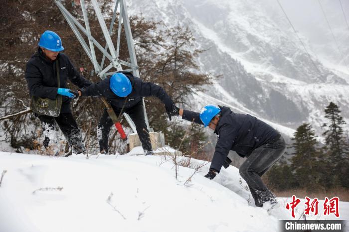 西藏波密縣電力巡護(hù)人員相互幫助，趟雪踏冰?！±顤|淮 攝