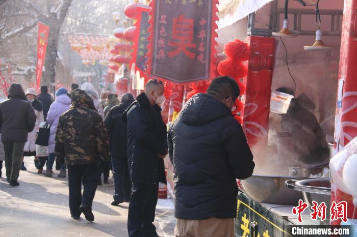 烏魯木齊市民在公園小吃攤上選購食品。　潘琦 攝