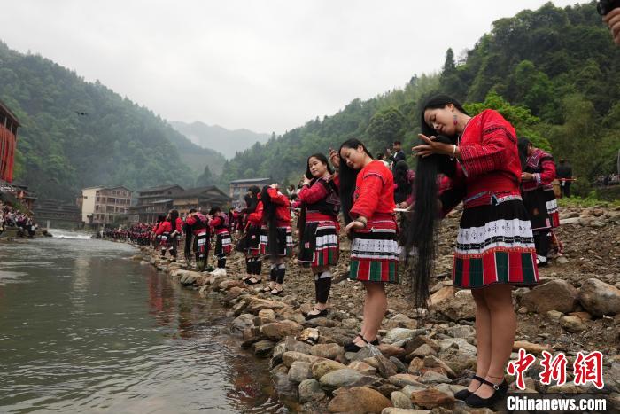 4月22日，在廣西龍勝各族自治縣龍脊鎮(zhèn)黃洛瑤寨，當(dāng)?shù)噩幾迕癖娫诤舆呴_(kāi)展長(zhǎng)發(fā)梳妝表演?！№f吉陽(yáng) 攝