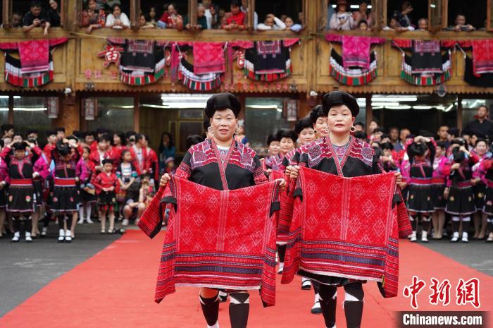 4月22日，在廣西龍勝各族自治縣龍脊鎮(zhèn)黃洛瑤寨，當(dāng)?shù)噩幾迕癖娫陂_(kāi)展紅瑤服飾T臺(tái)走秀?！菈?mèng)行 攝