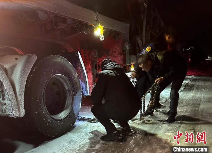 圖為民警幫助受困車輛安裝防滑鏈?！」逯菸麄鞑抗﹫D