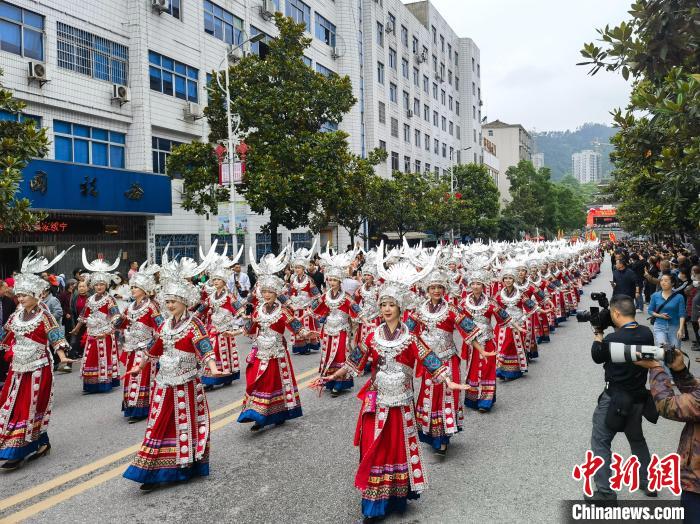 上百名美麗的姑娘著節(jié)日盛裝與蘆笙隊(duì)伍進(jìn)行巡游?！「毒窜?攝