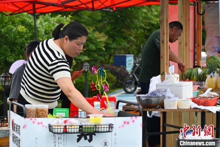 上金貝村村民擺攤售賣畬族美食?！∮嗌强?攝