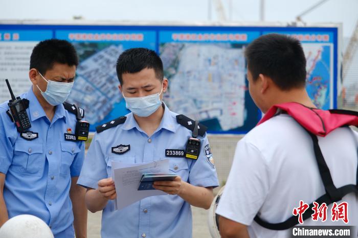 平潭邊檢站移民管理警察對(duì)船員證件進(jìn)行查驗(yàn)?！±钭谒?攝