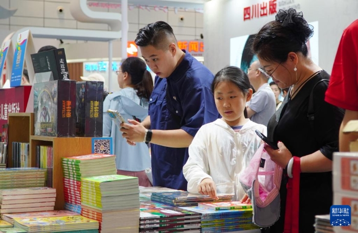 7月27日，在第31屆全國(guó)圖書(shū)交易博覽會(huì)上，讀者在閱覽新書(shū)。新華社記者 徐速繪 攝